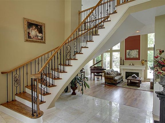   Sweeping staircase with updated wrought iron spindles.