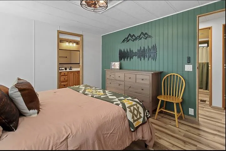 A beautifully decorated primary bedroom with an adjustable, therapeutic queen bed and rustic-inspired decor.
