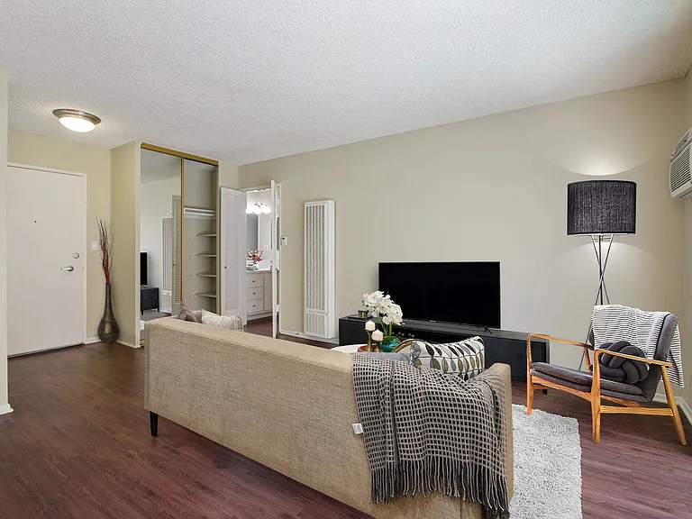 Wood-inspired floors in living room with a mirrored closet doors