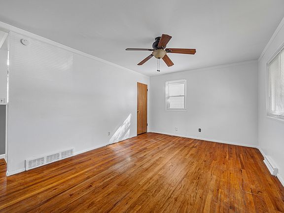 Living room w/ ceiling fan, coat closet & hardwood floors