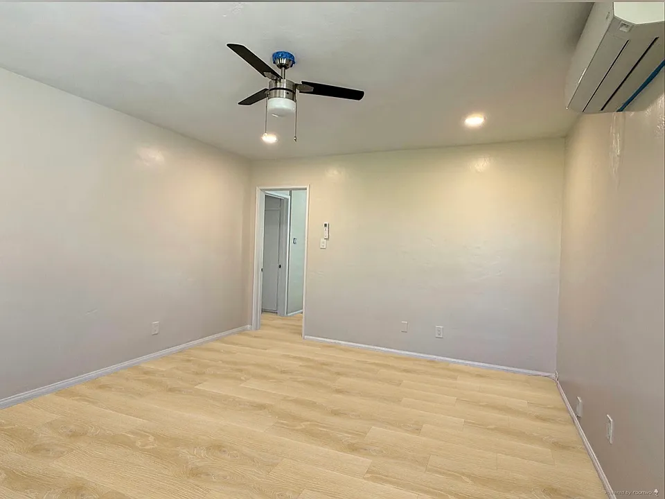 Living room with AC split and recessed lighting. North and east facing windows.