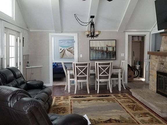 Living/dining room with large screen TV, leather furniture.