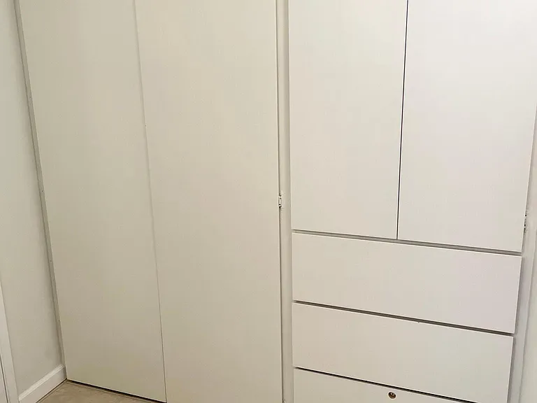 Bathroom vanity area has a large closet with a rod, shelves, and drawers. This area can be used as the apartment's storage.