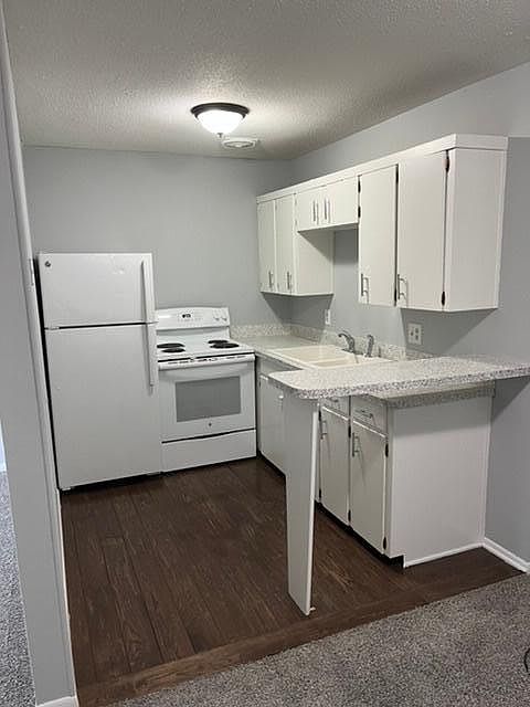 Kitchen with hardwood floor , stove and refrigerator.