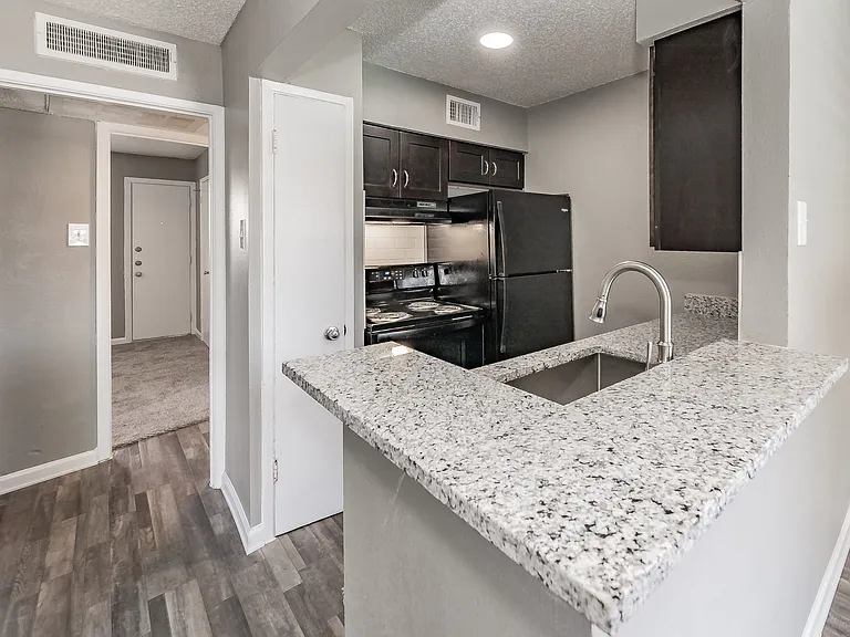 Enjoy cooking in stylish kitchens with dark cabinetry and granite-style counters at Chapel Creek Apartments.
