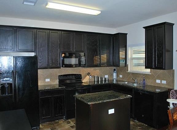 Great open kitchen with dark cabinets and granite counters