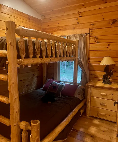 Third bedroom. Cozy twin over full bunkbeds. Has bear lamp and 3 drawer dresser. Nice size closet. Window view is to back area of cabin
