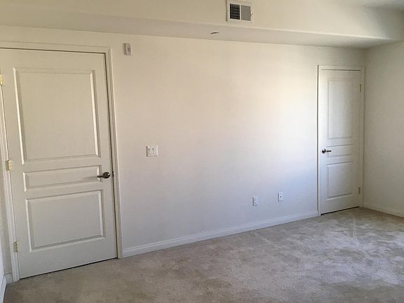 Bedroom with high ceilings, soft wall-to-wall carpet, and views of Main Street.