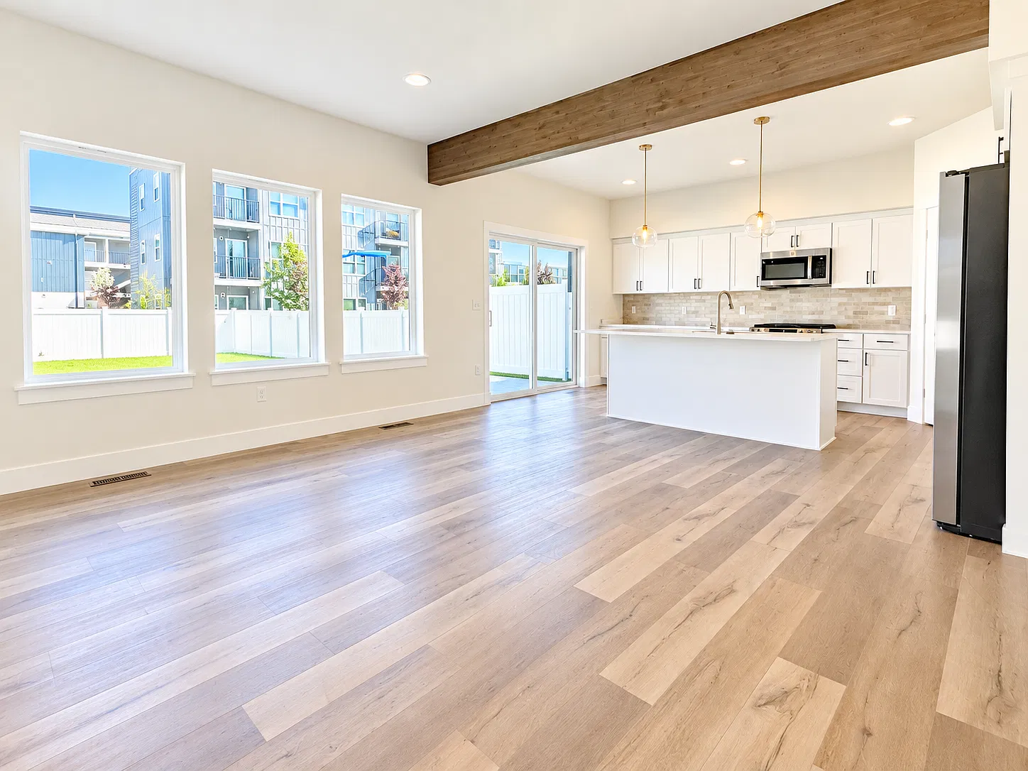 Living area adjoining kitchen with doors to back patio and yard