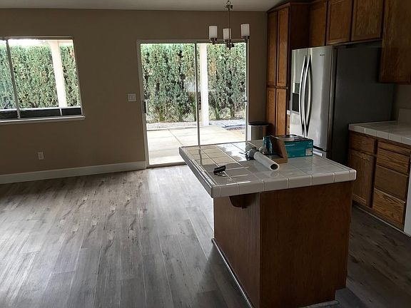Kitchen/Family room looks out onto the backyard. There is a covered patio with concrete slab for patio furniture.