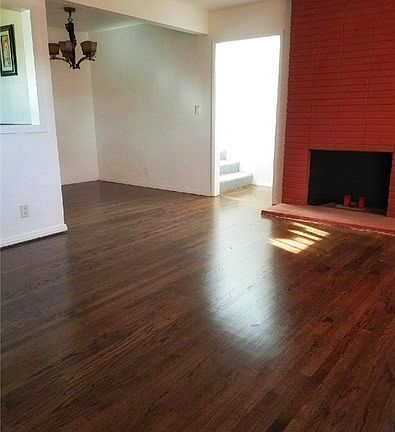Living Room with new paint, newly refinished oak hardwood floors, and the first grand fireplace of three fireplaces throughout the house.