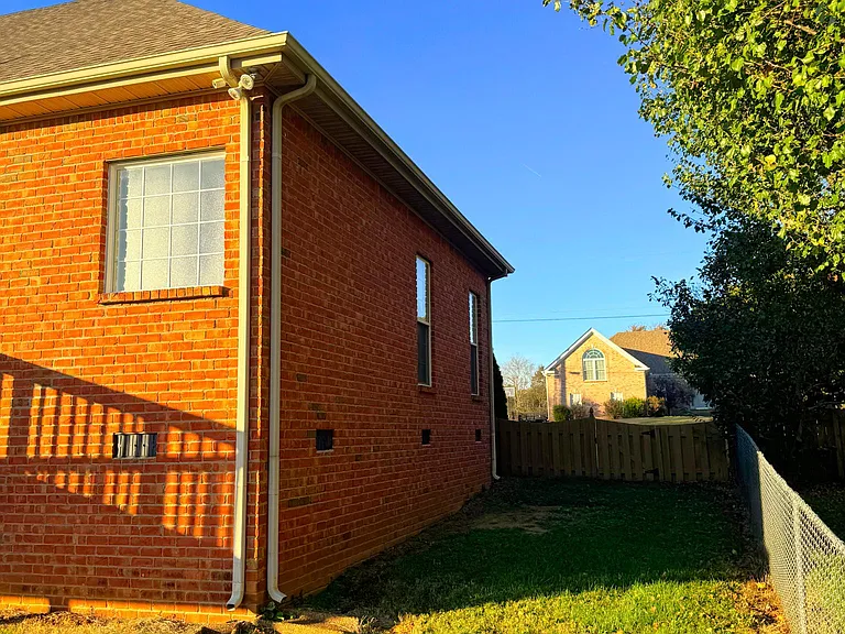 View of the left side of the house from the backyard - There is a second Hose connection here and the gate opens if needed