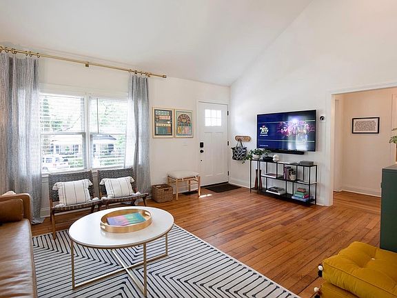 Open living room with vaulted ceiling and original hardwoods throughout