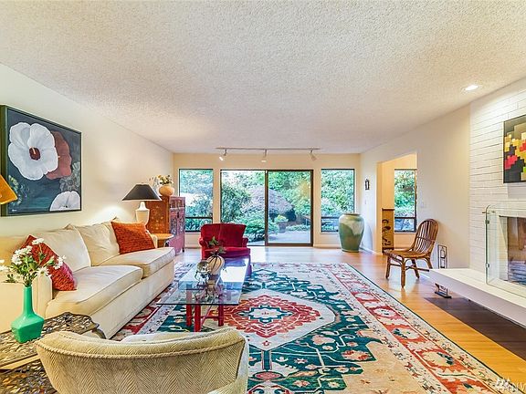A bright, inviting living room with sliding glass doors open to the back patio and beautifully landscaped garden, creating a seamless transition outside.