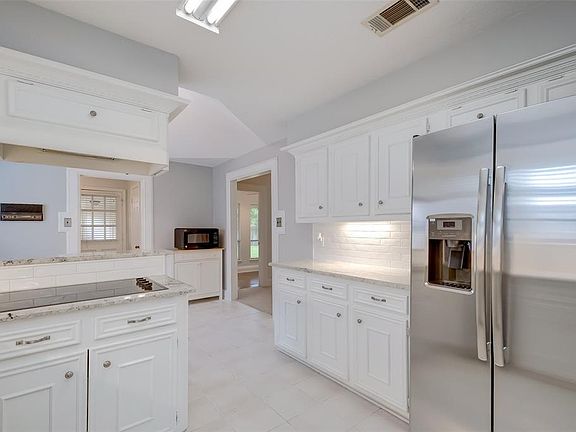 Another view of the kitchen featuring under cabinet lighting and new stainless steel refrigerator.