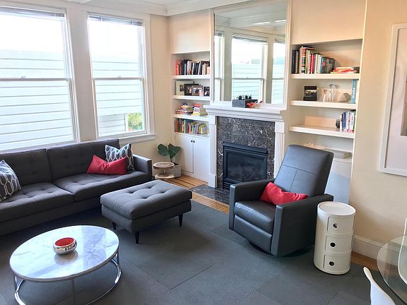 living room with gas fireplace, built-in bookshelves and cabinet (pre-renovation photo)