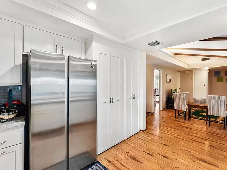 The kitchen is connected to the family room. On your right is a sliding door that leads to the covered patio and backyard which can be seen in the other pictures of the kitchen. The refrigerator is on the left side and the pantry is beside it.