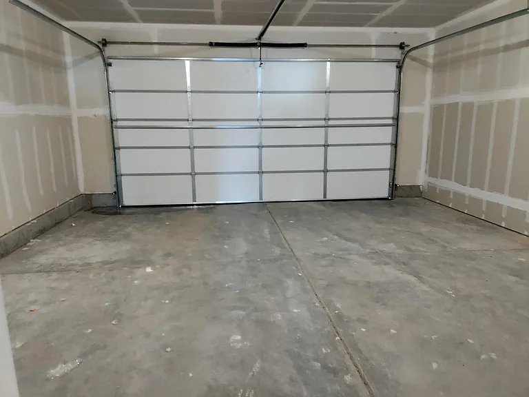Two car garage with dedicated parking outside to the left for larger vehicles