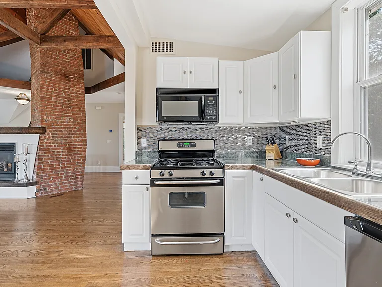 Updated, bright white kitchen with picture window features stainless steel appliances. (Remodeling will be complete in August).