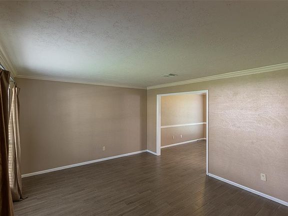 Formal living off entry with wood-look tile that flows into the formal dining and kitchen