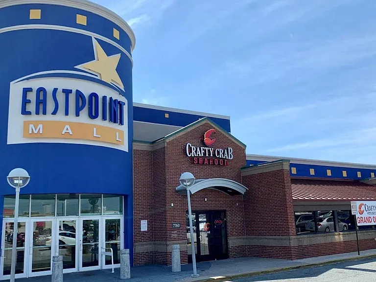 Street-facing commercial storefront with prominent signage, glass entry doors, and nearby parking for easy access.