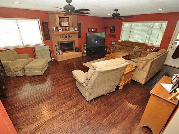 Wow, beautiful family room with ceiling fans and recessed lighting recently installed. Warm paint and laminate wood floors!
