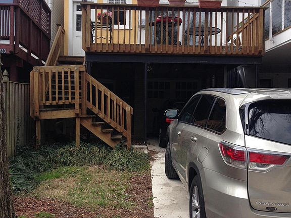 View from back of house. Parking for 3 cars total: 1 in garage, and two on driveway. Private deck and green space.