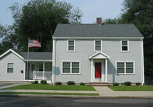 Front view showing new siding, roof, windows, and lawn