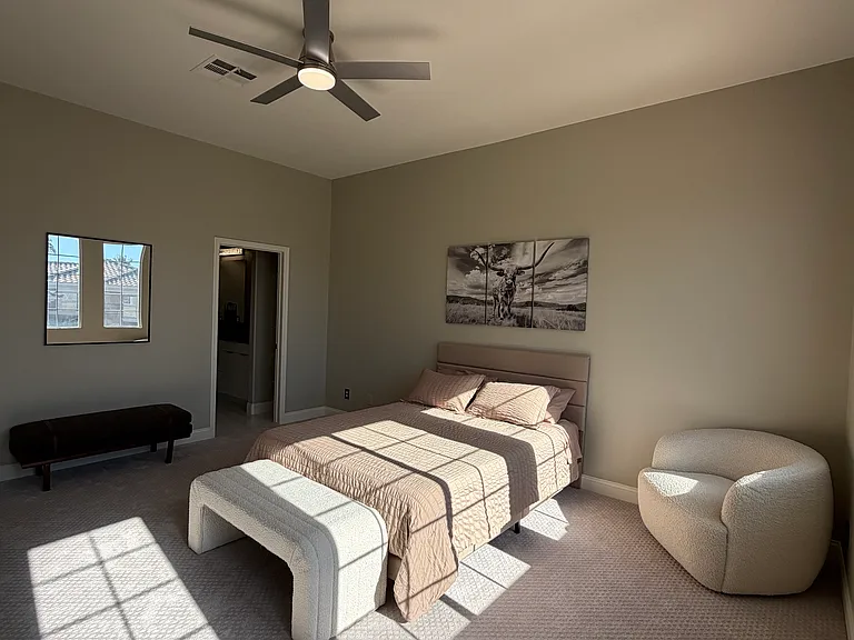 One of the larger bedrooms, filled with natural light from the four large windows, featuring a ceiling fan, generous closet space, and direct access to a shared Jack-and-Jill bathroom