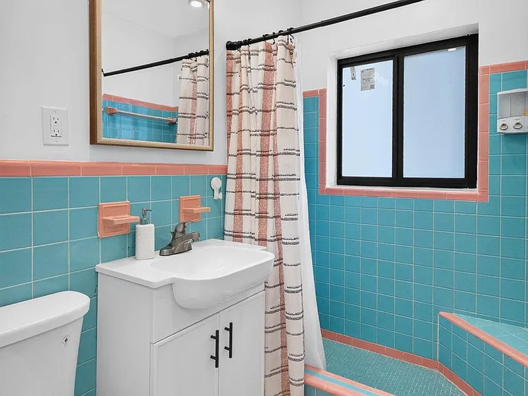 Full bathroom with a tub/shower, wide vanity storage, and a window for ventilation and natural light.
