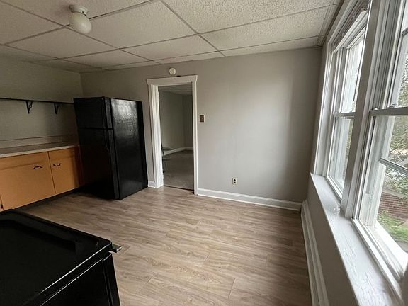 View of kitchen, open shelving and entrance to living room.