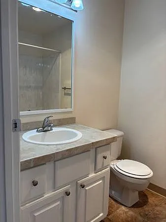 Updated bath with white cabinets and tiled vanity countertop.