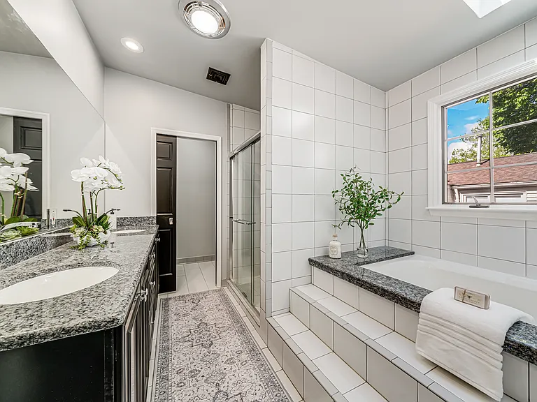 Primary bath with soaking tub, and frameless glass shower with seat