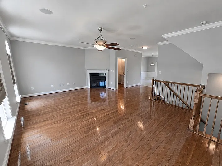 Spacious second floor living room with fireplace that opens into the dining room and kitchen.