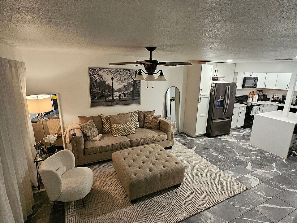 The first floor features an open-concept design, with the living room flowing seamlessly into the kitchen. A TV mount is installed and set up, ready for use.