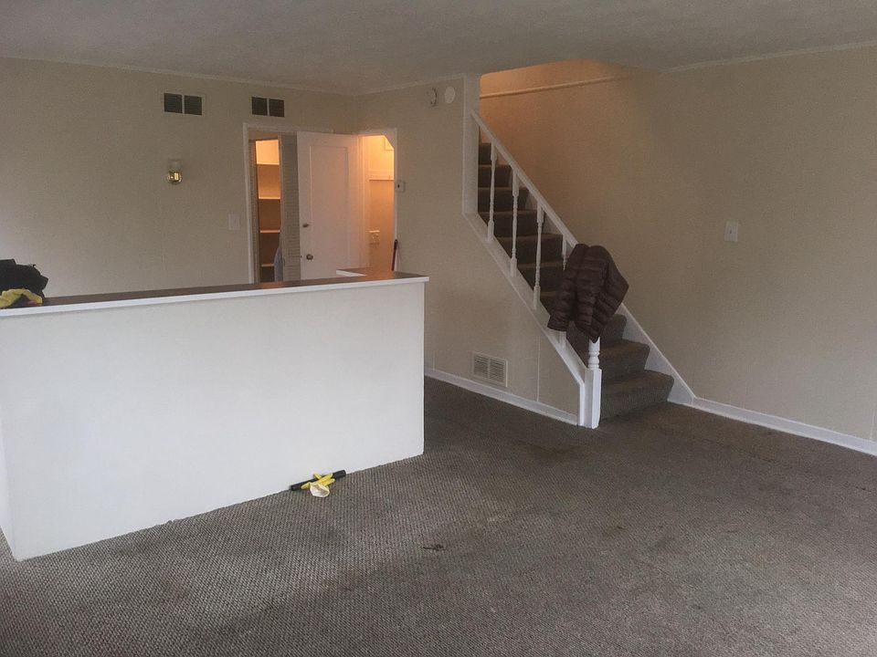 main room from entrance; 1/2 bath on right below stairs; kitchen, washer & dryer to left; door to backyard