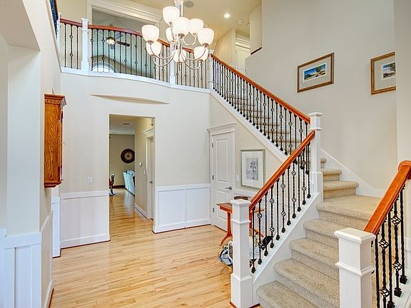 Spectacular Two Story Entry With Wrought Iron Spindle Staircase.