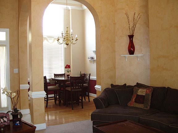 Formal dining room with arched doorways and hardwood floors.