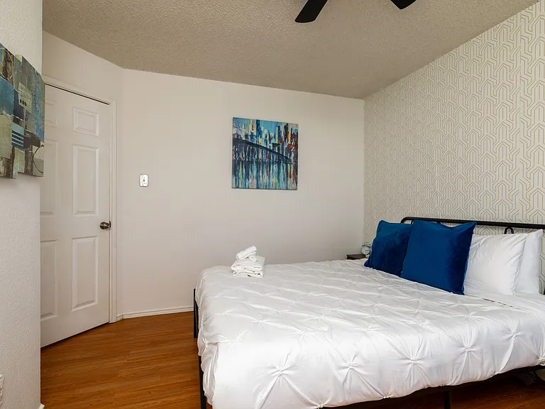 Stylish second bedroom with a queen bed and modern industrial touches.