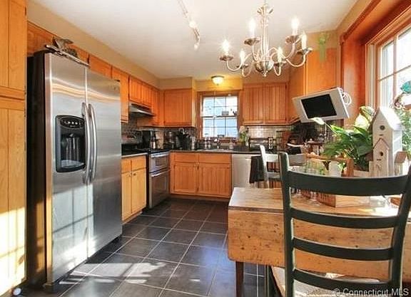 Updated kitchen complete with newer stainless steel appliances (including a GAS/double oven), new tiled floor, new stainless steel back splash and look to your right... that is a gorgeous, custom cherry trim around that big picture window letting in all t