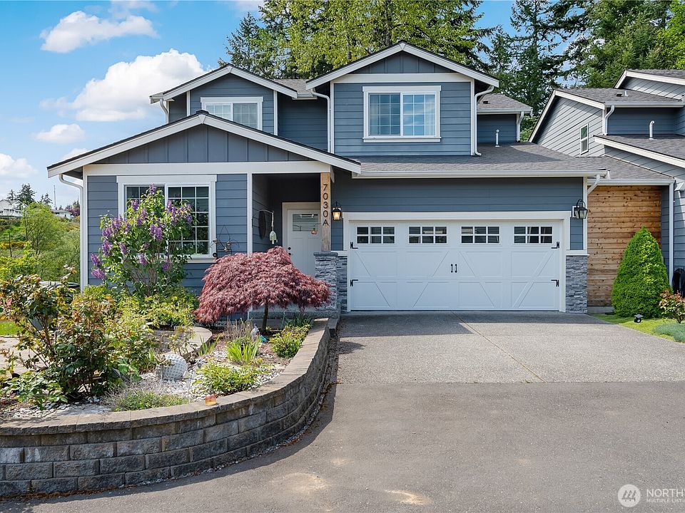 The inviting front of the house with the raised bed and rose garden.>