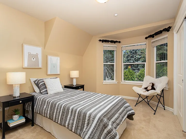 Upper level bedroom with bay windows, closet with built-in shelving or home office suite.