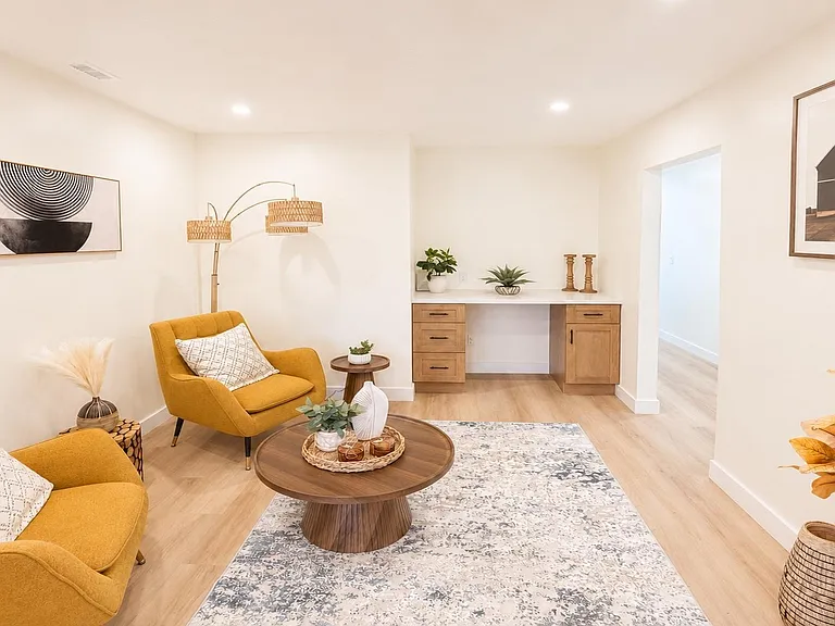 Welcoming living area with ample seating, a central coffee table, and a built-in desk nook for work or study.