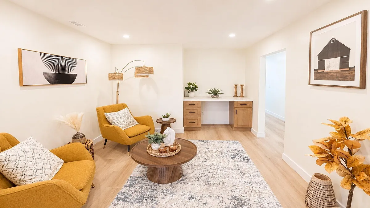 Welcoming living area with ample seating, a central coffee table, and a built-in desk nook for work or study. - Lausanne Dr