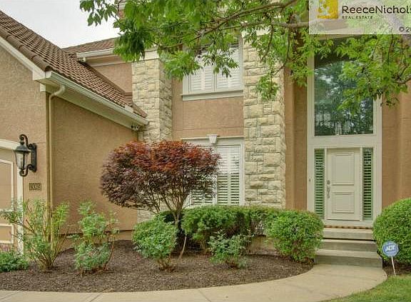 Tile roof and stone accents make this home stand out from the re