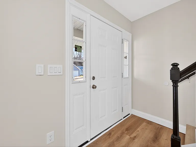 Entry foyer with wood-finished floors and stairs