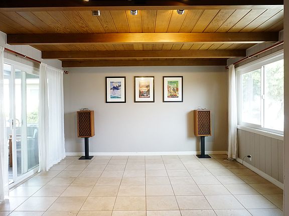 Bright living room with wood-paneled ceiling and overhead lighting.