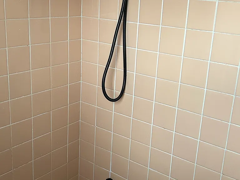 Updated shower fixture with full tub and tile surround.