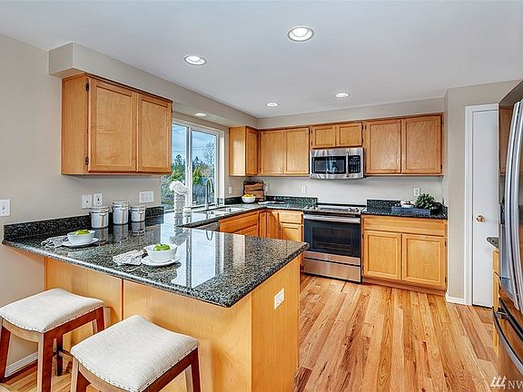 Find culinary inspiration in this well appointed kitchen, complete with stainless steel appliances, granite counter tops, pantry, and breakfast bar.