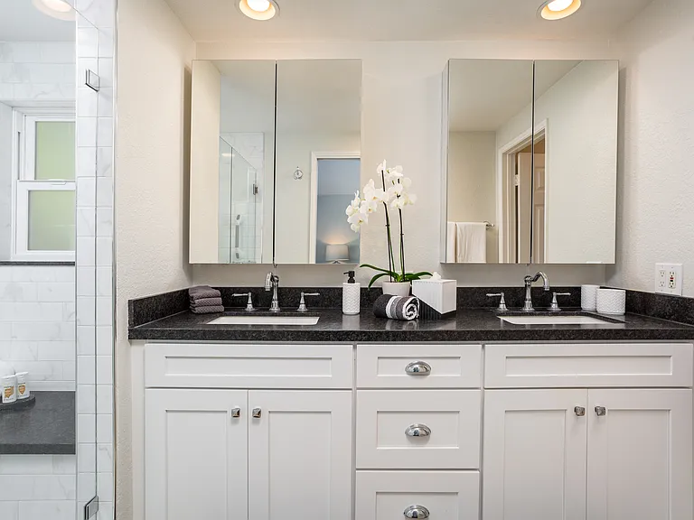 Double vanity sinks. Ample storage above and below sinks. Deep shower with wide seat.